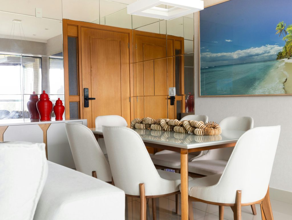 Elegant dining room with mirror decor and beach artwork in Salvador, Brazil.